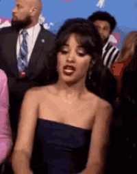 a woman in a blue strapless dress is sitting in a crowd .