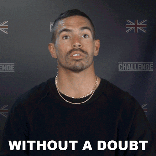 a man with a beard stands in front of a wall that says the challenge