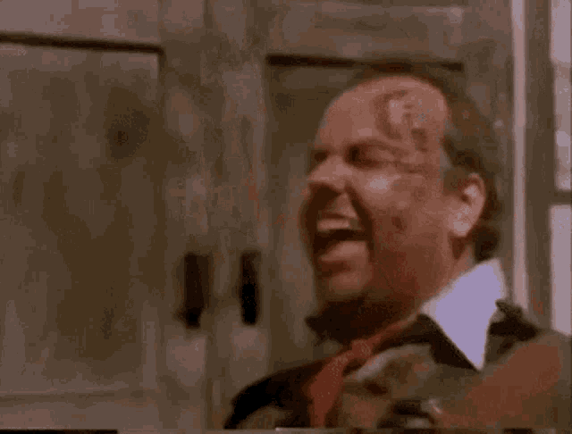 a man with a bloody face is smiling in a video .