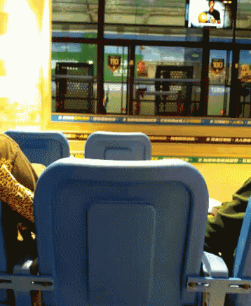 a person sitting in a stadium watching a game with a sign that says rio on it