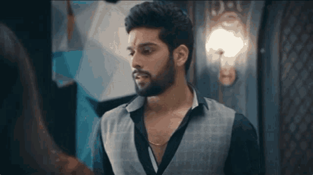 a man with a beard is standing in front of a woman in a room .