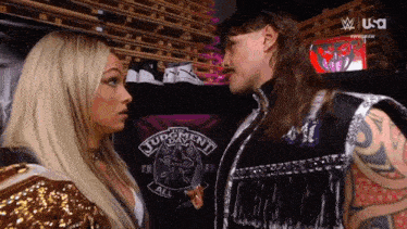 two wrestlers are looking at each other in front of a judgement day shirt