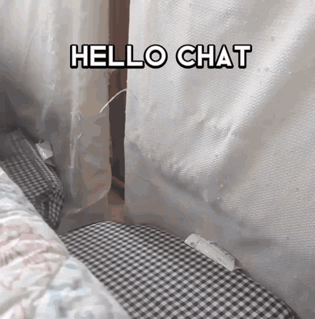 a bed with a checkered blanket and the words hello chat above it