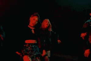 a group of people are dancing together in a dark room .