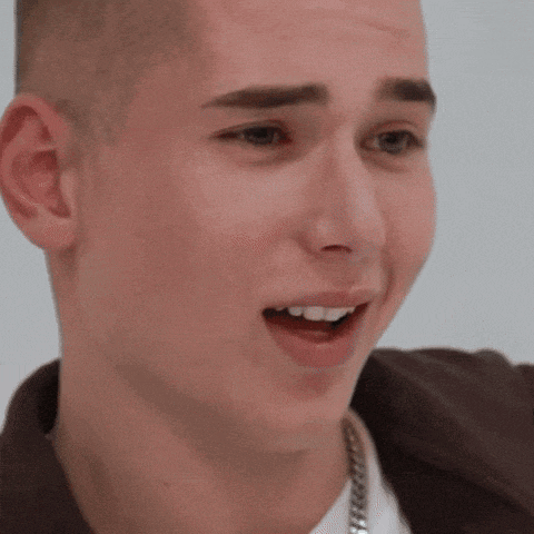 a close up of a young man 's face with a chain around his neck