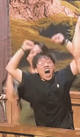 a man wearing glasses and a black shirt is screaming with his mouth open