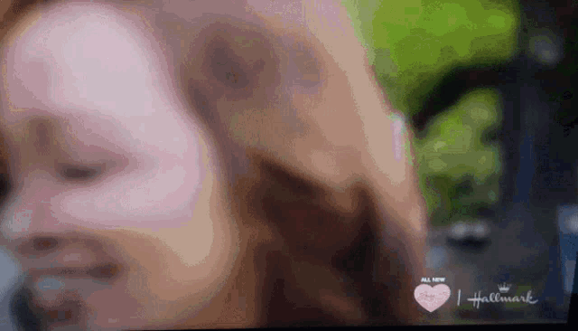 a close up of a woman 's face with a hallmark logo on the bottom