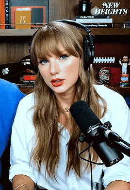 a woman wearing headphones and a microphone is talking into a microphone .