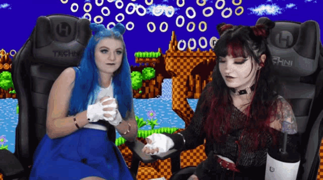 two women are sitting in chairs that say techni on them