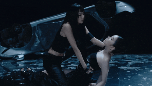 a woman holding another woman 's head with a ring on her finger