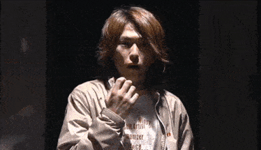 a man with long hair is wearing a t-shirt that says " wings " on it