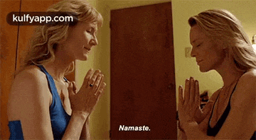 a woman is praying in front of a mirror and says namaste .