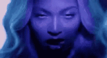 a close up of a woman 's face with purple hair and black lipstick .