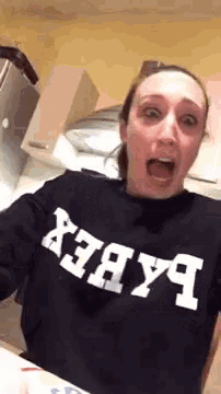 a woman is wearing a black sweatshirt with the word baby on it .