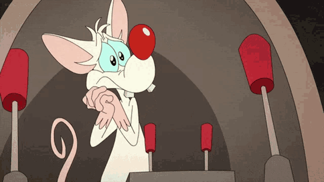 a cartoon mouse with a red nose is standing in front of some red buttons