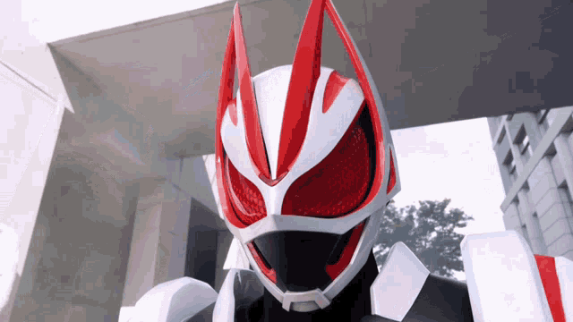 a close up of a red and white robot with a helmet