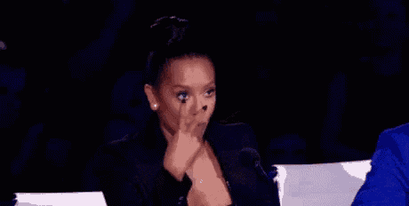 a woman is sitting in a chair with her hand on her face .