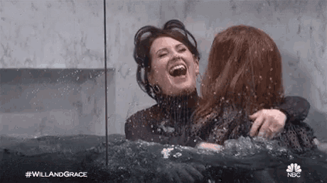 two women are hugging each other in a bathtub .