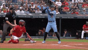 a baseball game is being played in front of a sherwin williams banner