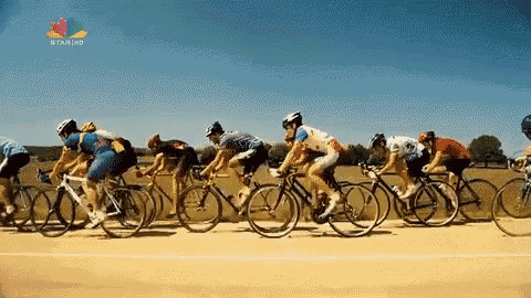 a group of people riding bicycles on a track with star hd in the corner