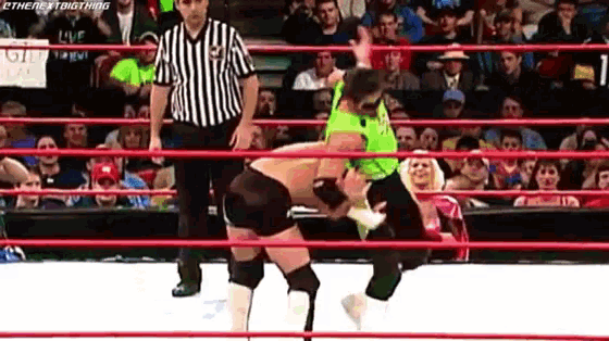 two wrestlers are in a ring with a referee and a sign that says live on it