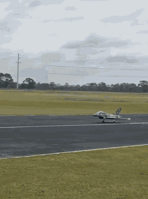 a fighter jet is taking off from a runway with the letters df on its tail