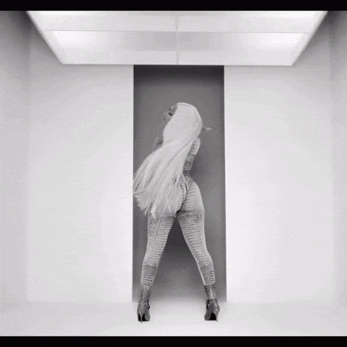 a woman with very long white hair is standing in a white room