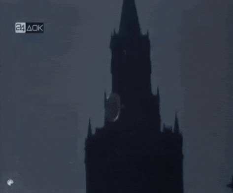 a clock tower is silhouetted against a dark sky with a 24 aok logo in the upper right corner