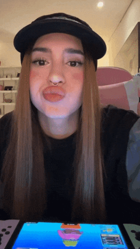 a woman wearing a hat is making a funny face