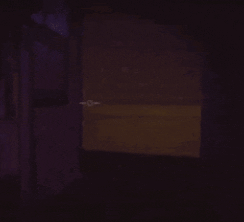 a cartoon baby in a diaper is holding a spoon in his hand in the dark .