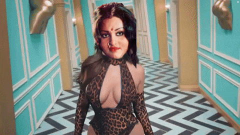 a woman in a leopard print outfit is walking down a hallway