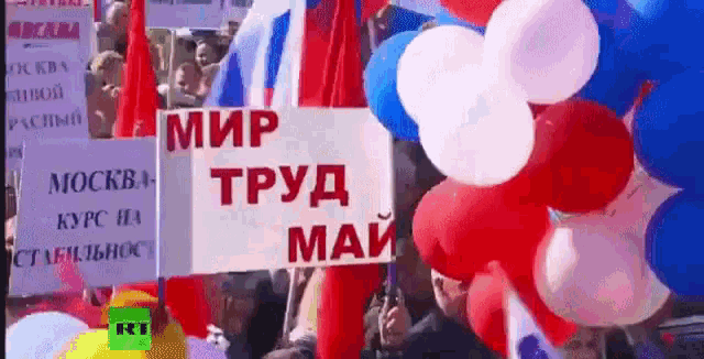 a sign that says " мир труд май " surrounded by balloons