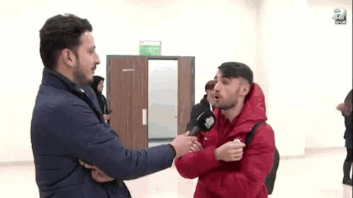 a man in a red jacket is being interviewed by a reporter