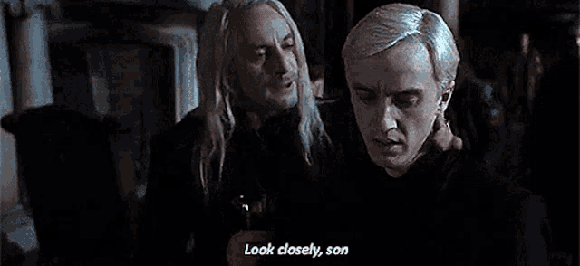 a couple of men are standing next to each other and one of them is talking to the other .
