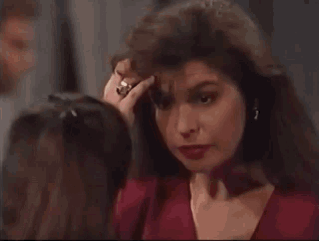 a woman with a ring on her finger touches her forehead