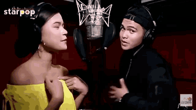 a man and a woman wearing headphones singing into microphones .