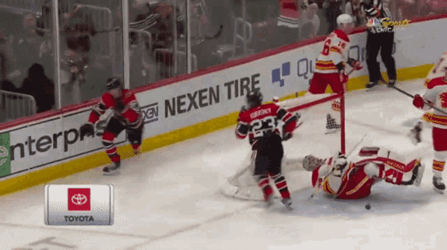 a hockey game is being played on a toyota sponsored rink