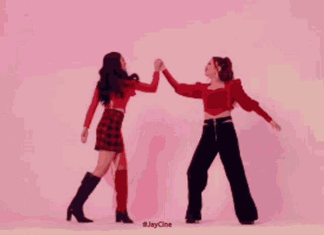 two women are dancing in front of a pink background and the hashtag #jaycine is on the bottom