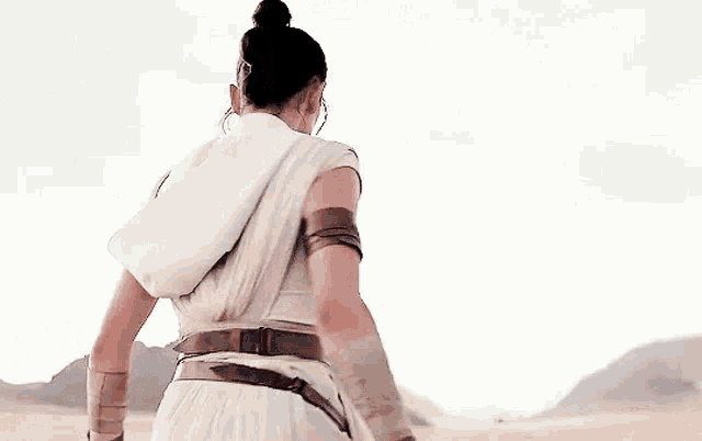 a woman in a white dress is standing in the desert .