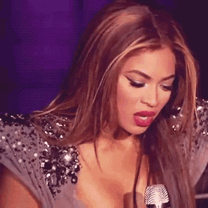 a woman is singing into a microphone while wearing a very revealing dress .