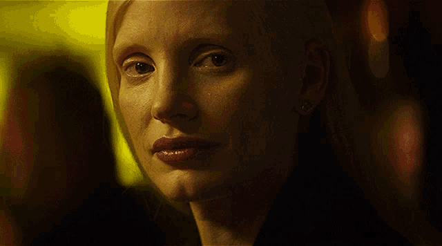 a close up of a woman 's face with a dark background