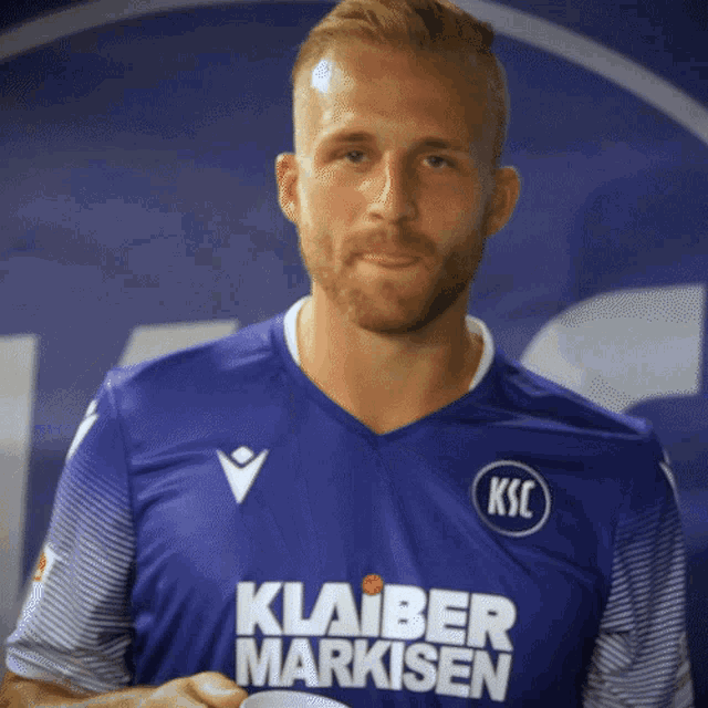 a man wearing a blue shirt that says klaiber markisen on it
