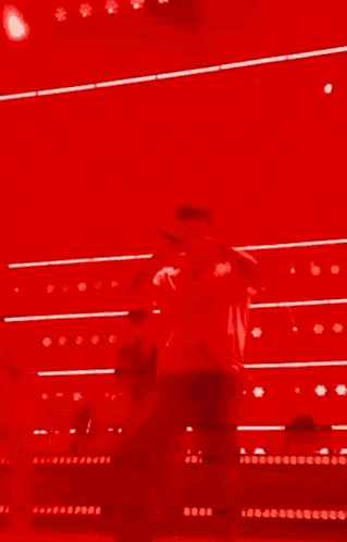 a man in a white shirt is singing into a microphone on stage