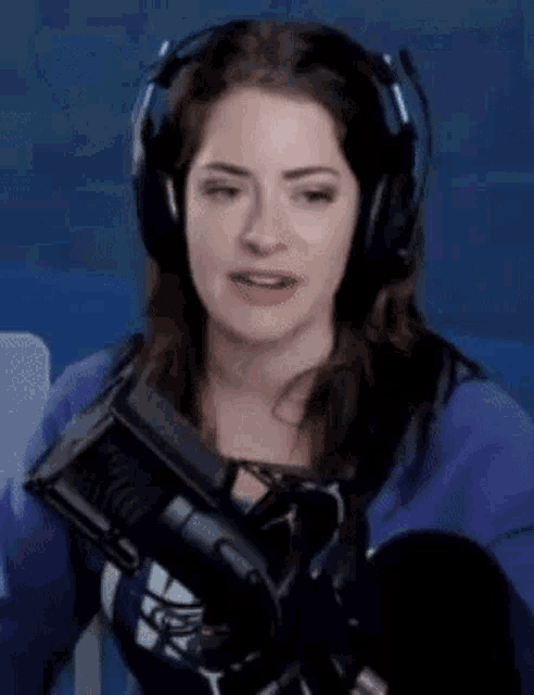 a woman wearing headphones and a microphone is sitting in front of a microphone .