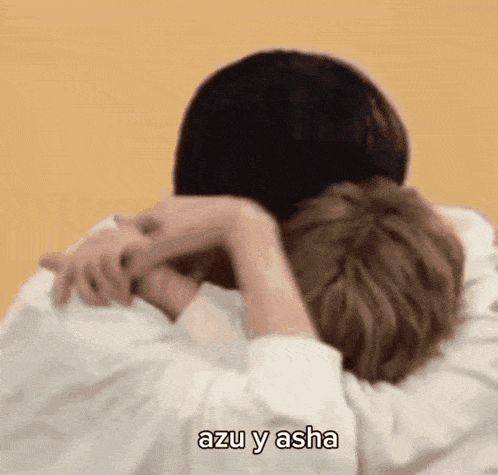 a couple of people hugging each other with the words `` azu y asha '' written above them .