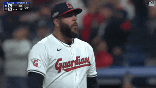 a baseball player wearing a guardians jersey looks to his left
