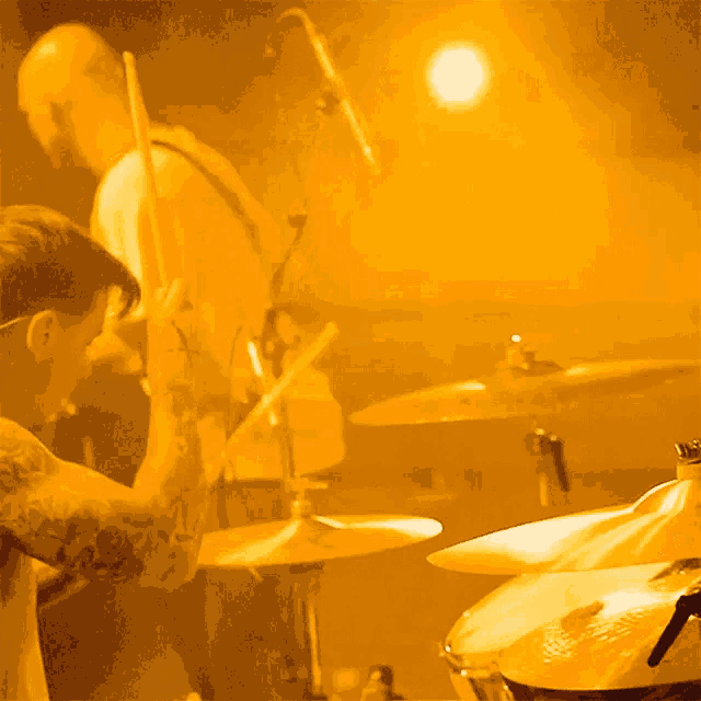 a man playing drums in front of a microphone