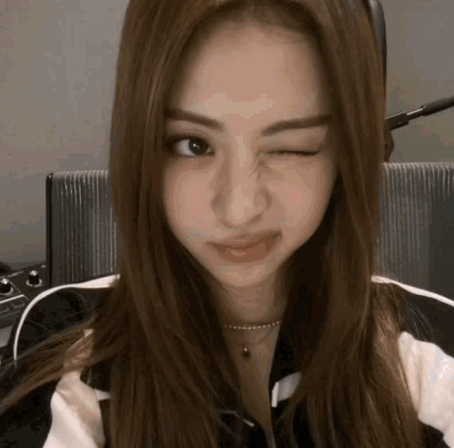 a close up of a woman making a funny face with her eye closed