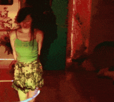 a woman in a floral dress is dancing in a dark room