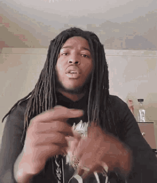 a man with dreadlocks is making a funny face